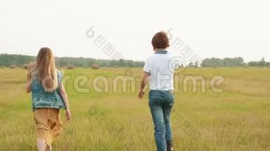十几岁的<strong>男孩</strong>和<strong>女孩</strong>在干草堆背景下的收割场上散步。 后景<strong>男孩女孩</strong>走着